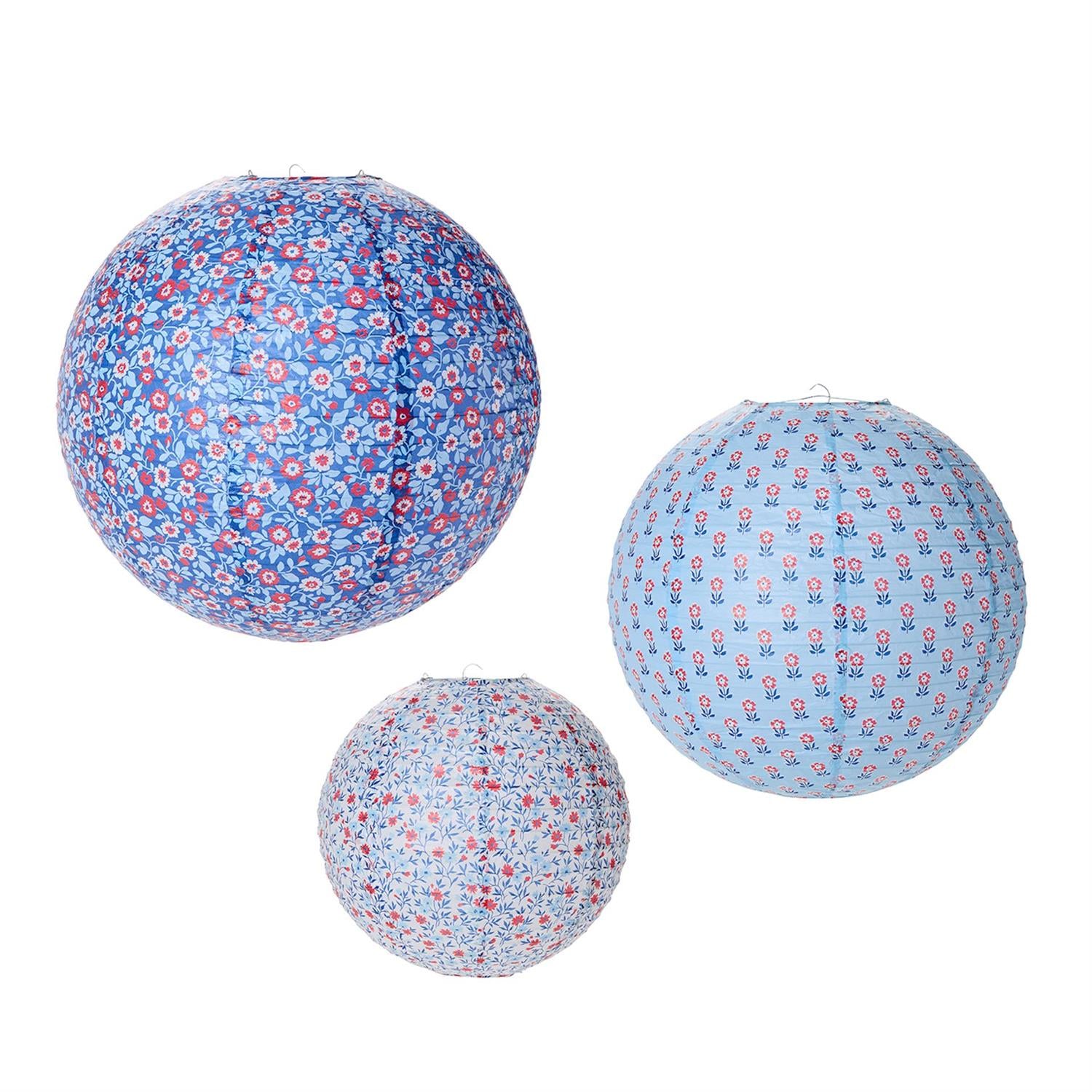 Three floral-patterned paper lanterns on a white background