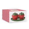 Strawberry-shaped containers on a green plate in a red and white checkered box.