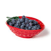 Red strawberry-shaped bowl filled with blueberries on a white background