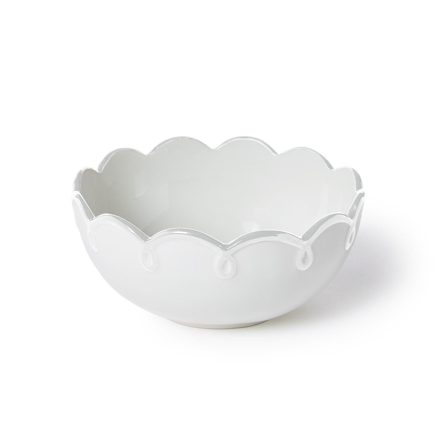 White ceramic bowl with scalloped edge on a white background
