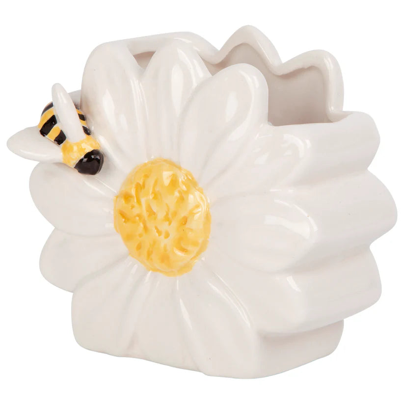 White ceramic flower-shaped scrubbie holder container with a yellow center and black and yellow bee on a white background