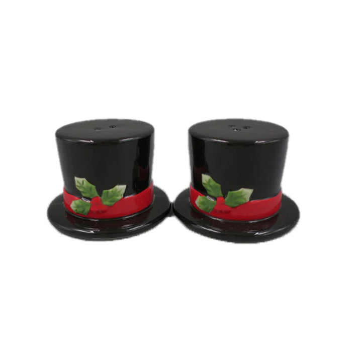 Two black top hats with red bands and green holly leaves and berries on a white background