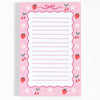 A pink lined notepad with a strawberry and cherry border design, featuring a scalloped edge and the brand name 'pippi post' at the bottom.
