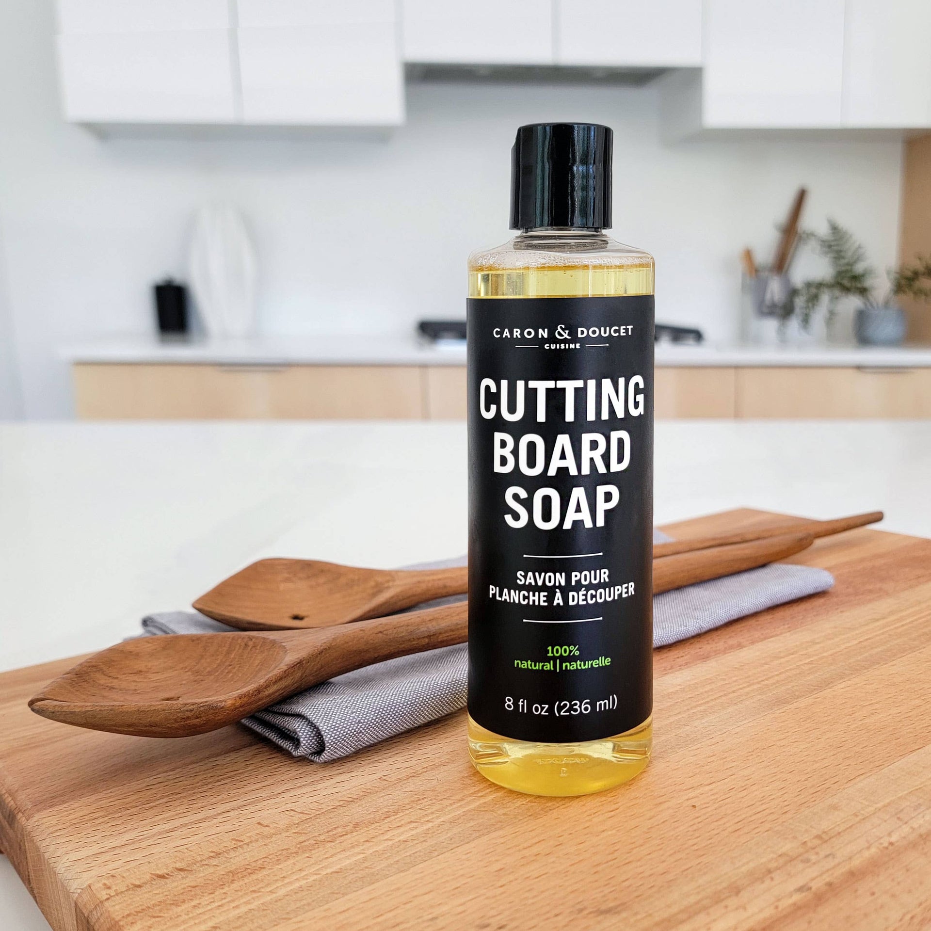 Bottle of cutting board soap on a wooden cutting board in a kitchen setting