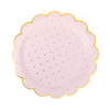 Round pink plate with gold polka dots and a scalloped edge on a white background