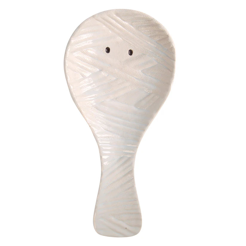 White ceramic spoon rest with mummy design on a white background