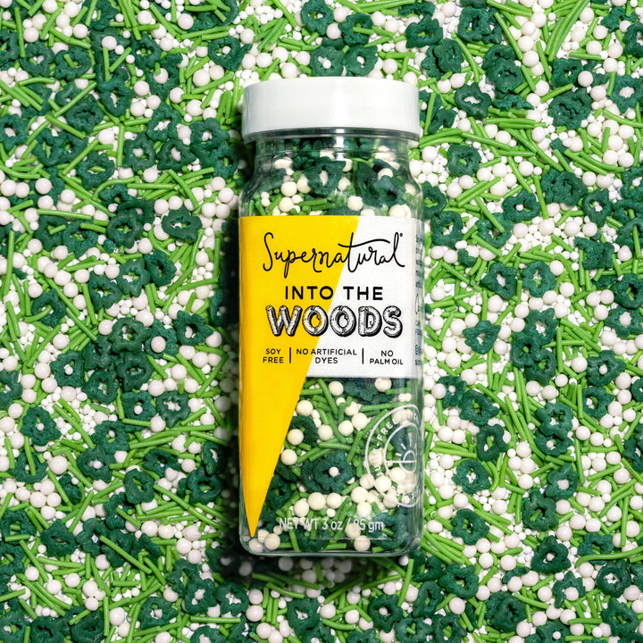 Bottle of 'Supernatural Into The Woods' sprinkles on a bed of green and white sprinkles.