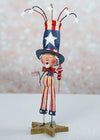 Decorative figure of a patriotic character with a top hat and American flag on a star-shaped base.