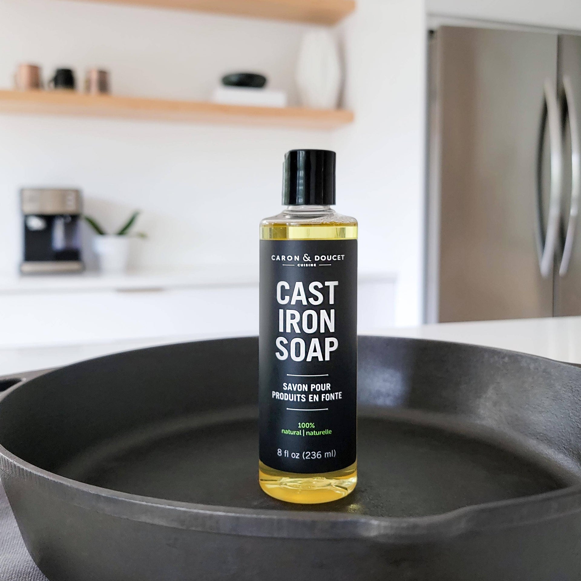 Bottle of Cast Iron Soap on a cast iron skillet in a kitchen setting