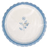 Round white plate with blue floral design and scalloped edge on a white background