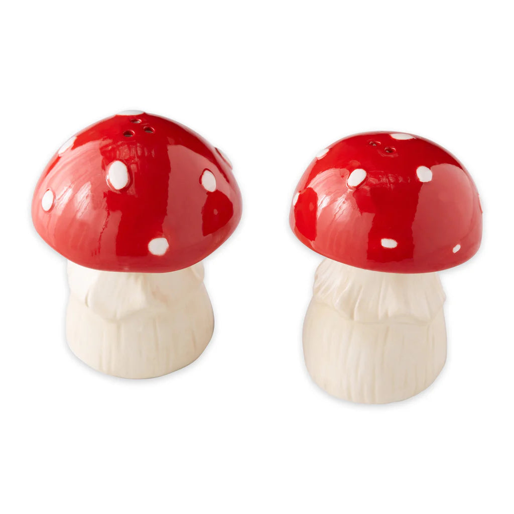 Mushroom-shaped salt and pepper shakers with red caps and white stems on a white background