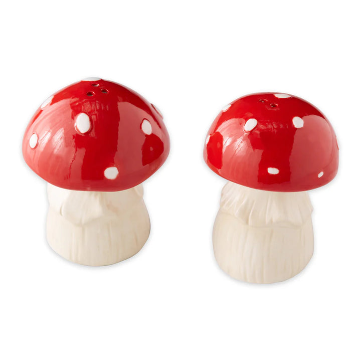 Mushroom-shaped salt and pepper shakers with red caps and white stems on a white background