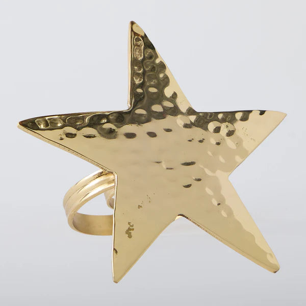 Gold star-shaped napkin ring on a light gray background