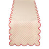 Beige table runner with red scalloped edge and subtle heart pattern on a white background