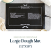 Bakehouse Essentials large black dough mat with instructions and branding on a gray surface.