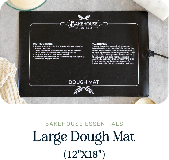 Bakehouse Essentials large black dough mat with instructions and branding on a gray surface.