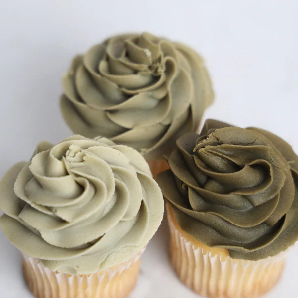 Three cupcakes with tan/brown frosting on a white background