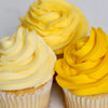 Three cupcakes with yellow frosting on a white background