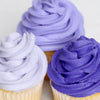 Three cupcakes with purple frosting on a white background