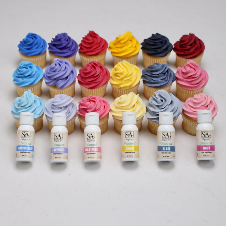 Cupcakes with colorful frosting and corresponding bottles of food coloring on a white background