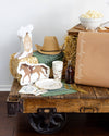 Decorative setting with a wooden cart, cowboy hat, and horse plate