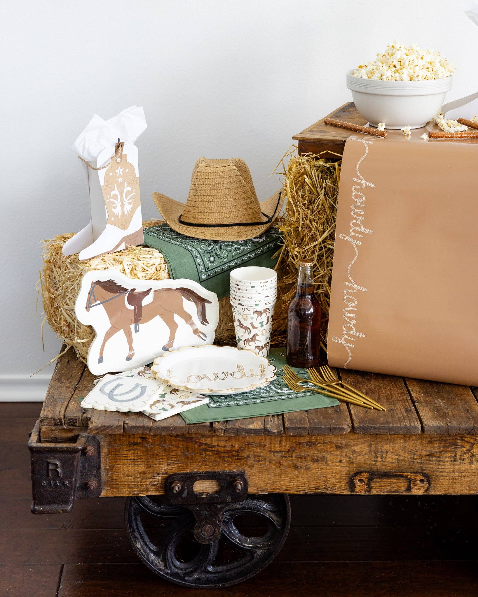 Decorative setting with a wooden cart, cowboy hat, and horse plate