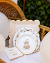 Decorative plates with teddy bear design on a table with balloons and a basket.