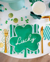 St. Patrick's Day-themed table setting with a green shamrock plate, gold coins, and clover decorations.