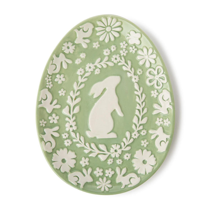 Decorative plate with white floral and rabbit design on a white background