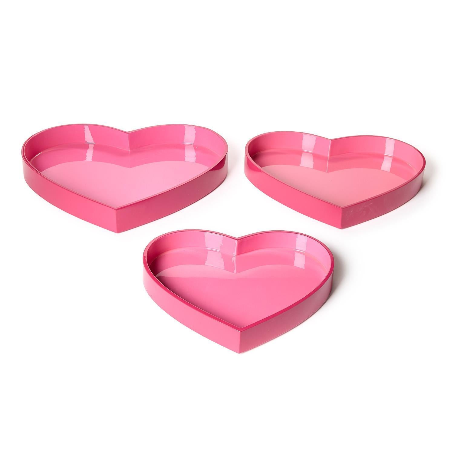 Three pink heart-shaped trays on a white background