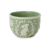 Green bowl with white floral and rabbit design on a white background