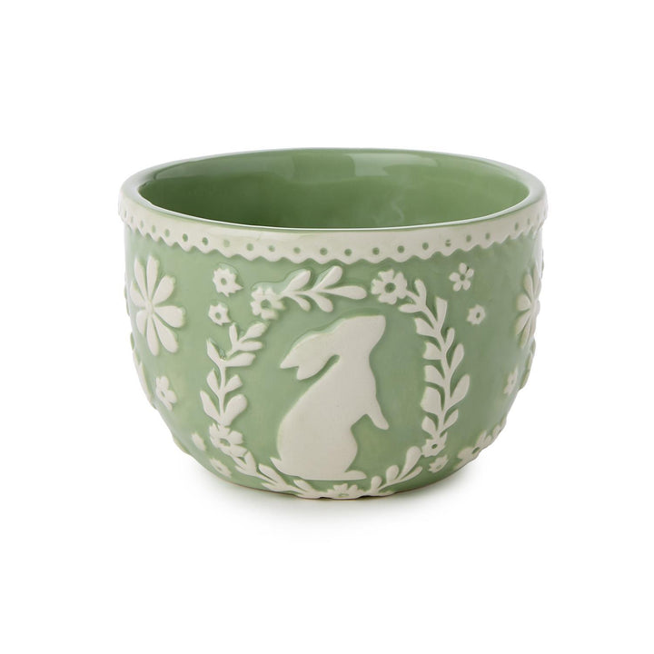 Green bowl with white floral and rabbit design on a white background