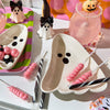 Halloween-themed treats including ghost-shaped bowls, candy, and drinks on a table.
