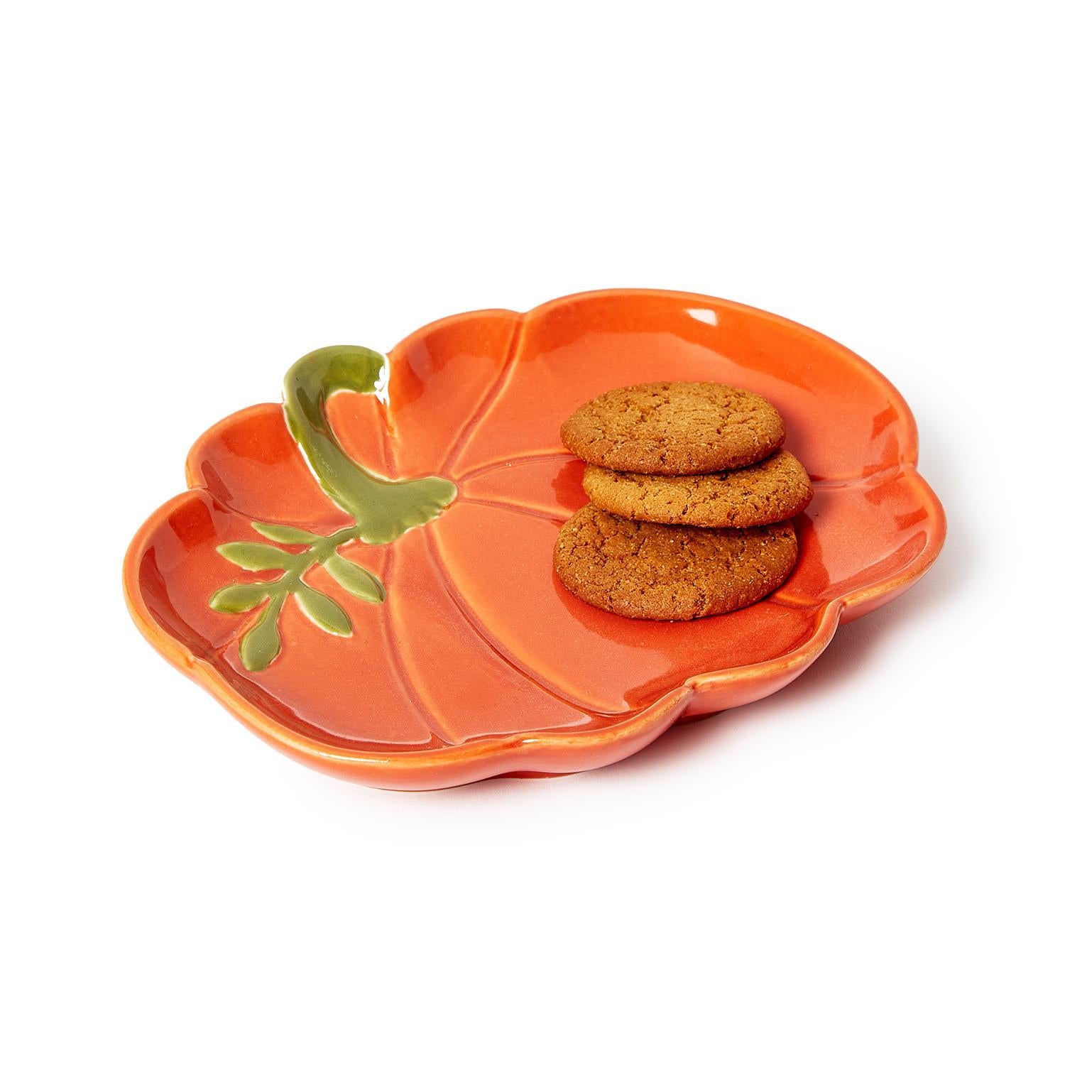 Orange pumpkin-shaped plate with cookies on a white background