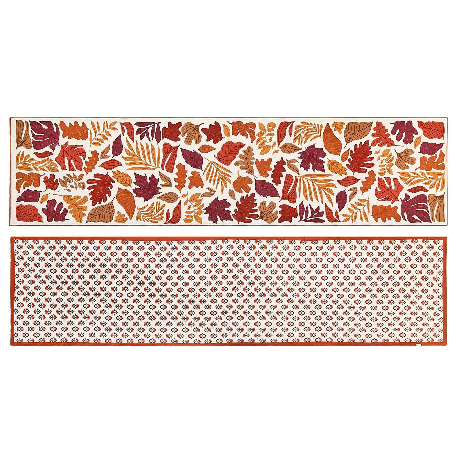 Reversible table runner with autumn leaf design on a white background