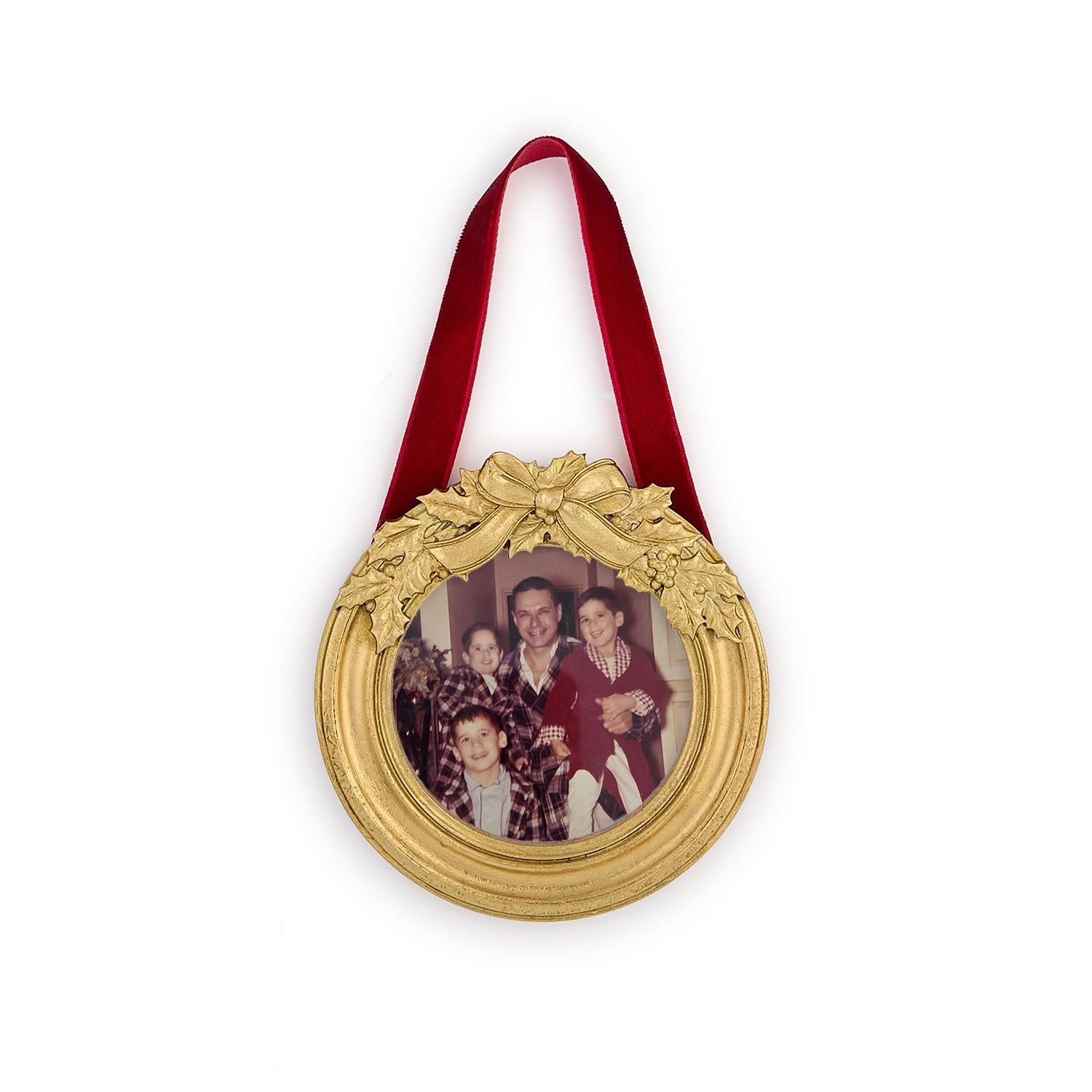 Decorative gold frame with a family photo inside, hanging on a white background