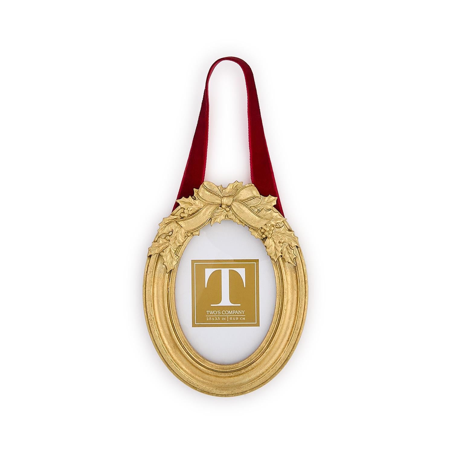 Decorative gold frame with a red ribbon and holly leaf embellishments on a white background