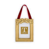 Gold decorative frame with a red ribbon and holly leaf embellishments on a white background