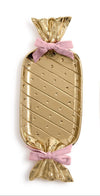 Gold candy-shaped tray with pink ribbons on a white background