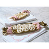 Two gold candy-shaped trays with white goodies on a white surface