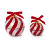 Two red and white striped ornament-shaped candles with red ribbons on a white background