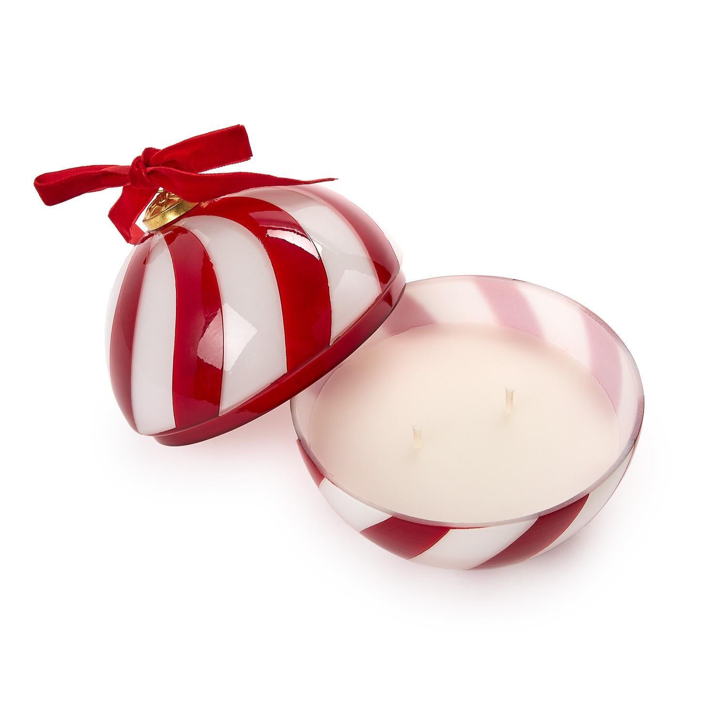 A red and white striped ornament-shaped candle with red ribbon on a white background