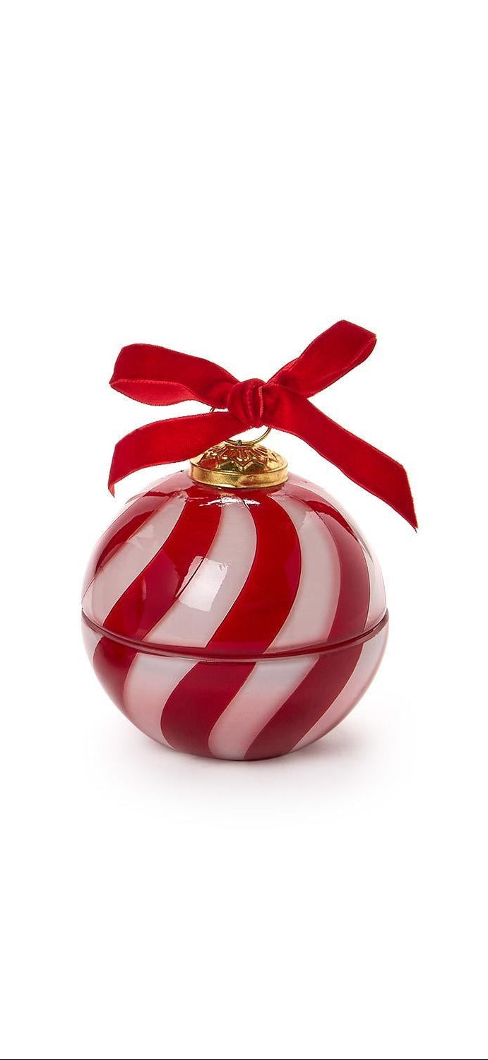 A red and white striped ornament-shaped candle with red ribbon on a white background