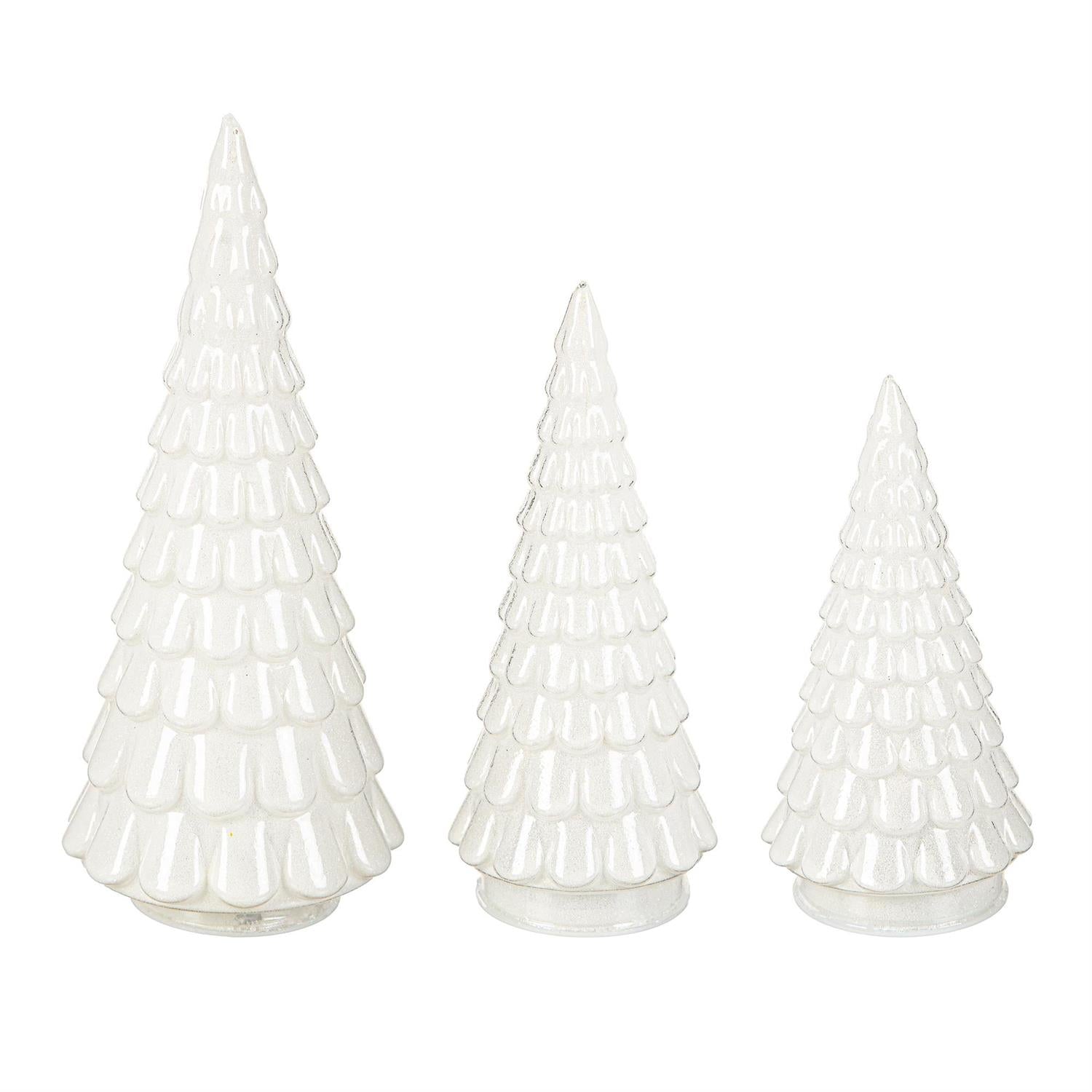 Three white Christmas tree figurines of different sizes on a white background