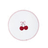 A white circular coaster with a red dashed rim and a central embroidered design of two red cherries tied with a pink bow.