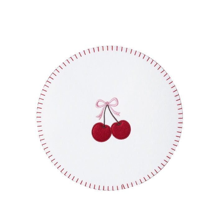 A white circular coaster with a red dashed rim and a central embroidered design of two red cherries tied with a pink bow.