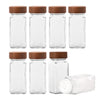Set of glass spice jars with wooden lids on a white background