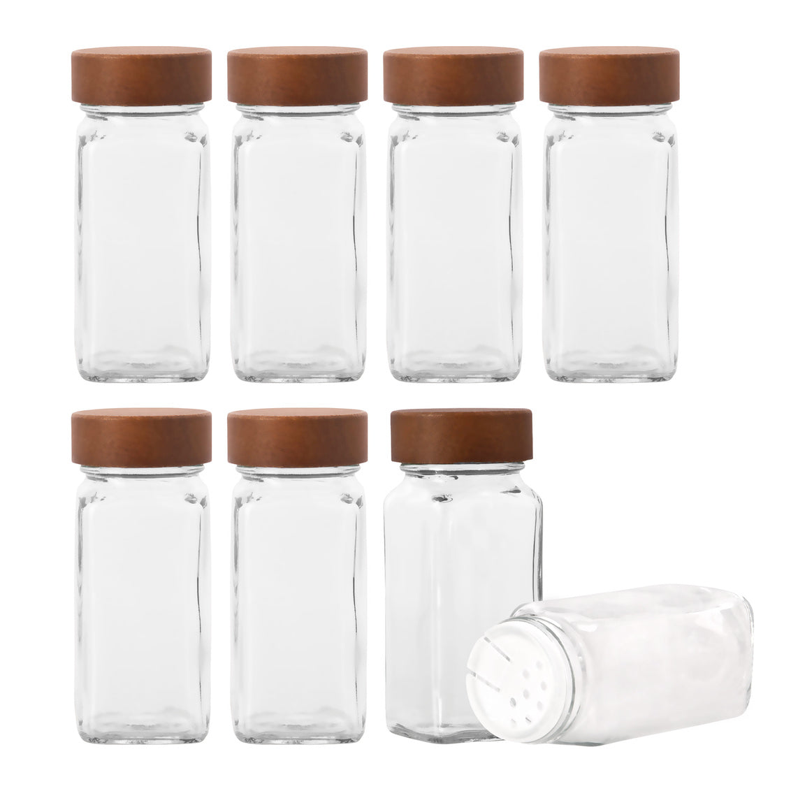 Set of glass spice jars with wooden lids on a white background