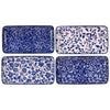 Set of four blue and white patterned trays on a white background