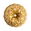 Gold decorative bundt pan with intricate leaf pattern on a white background
